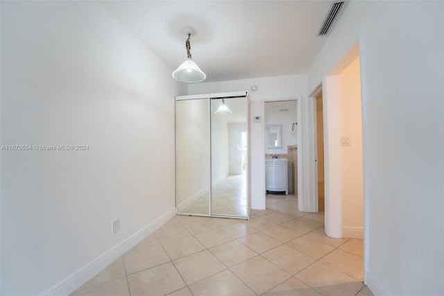 unfurnished bedroom with light tile patterned flooring and a closet