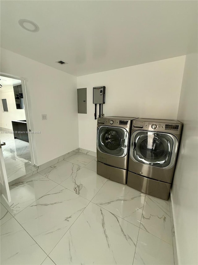 laundry area with electric panel and separate washer and dryer