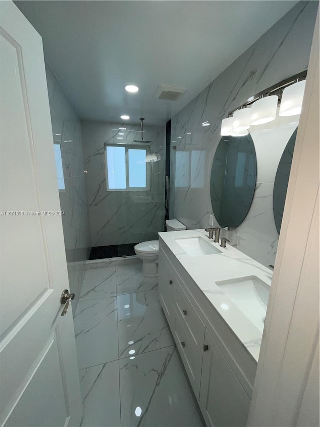 bathroom featuring a tile shower, vanity, and toilet