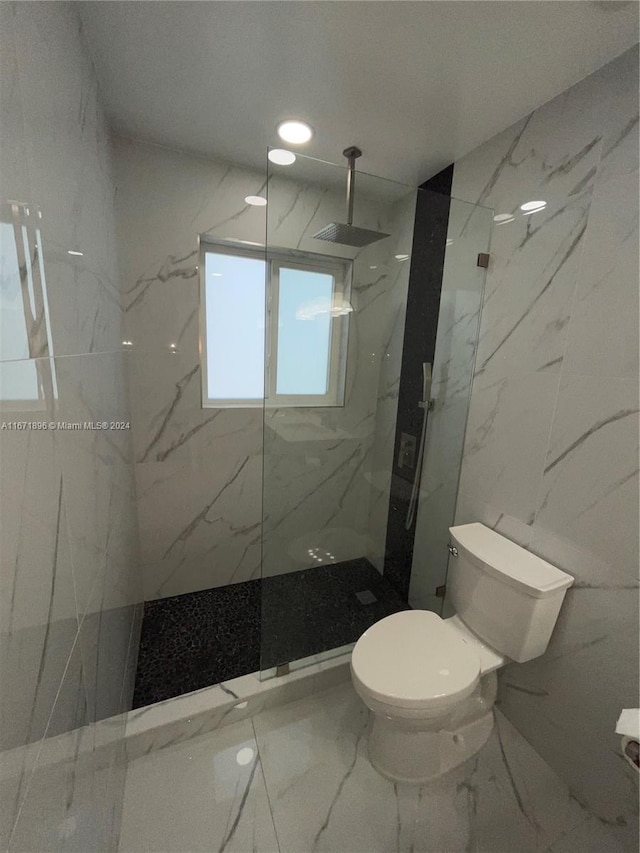 bathroom featuring toilet, tiled shower, and tile walls