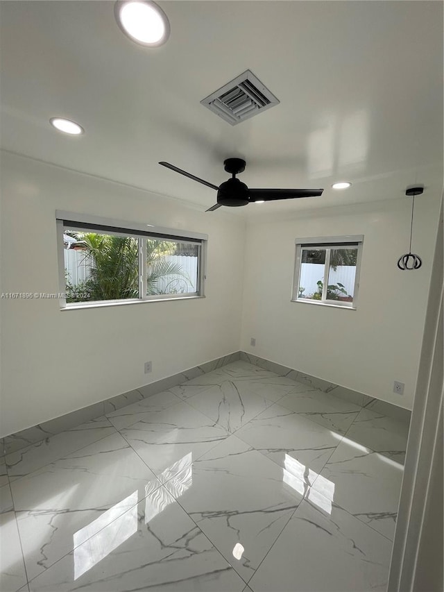 empty room featuring plenty of natural light and ceiling fan