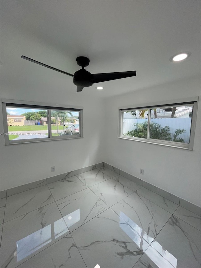 unfurnished room with ceiling fan and plenty of natural light