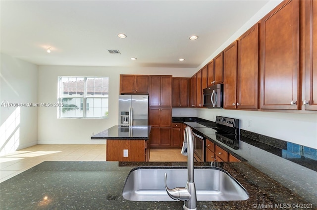 kitchen with visible vents, dark stone countertops, stainless steel appliances, a sink, and recessed lighting