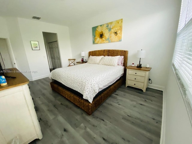 bedroom with dark wood-type flooring and a closet