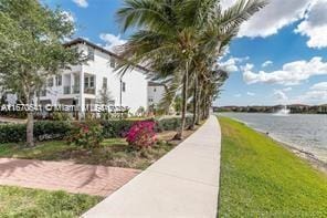 view of property's community featuring a water view and a lawn