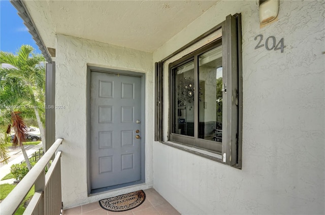 view of exterior entry with a balcony