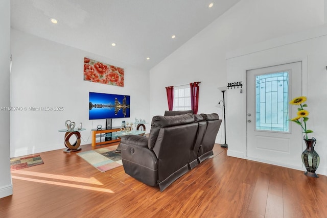 living room featuring high vaulted ceiling and wood-type flooring