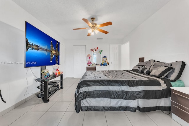 tiled bedroom with a textured ceiling and ceiling fan