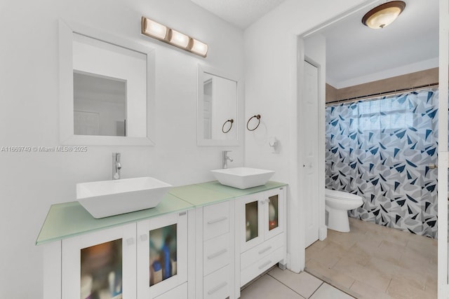 bathroom with tile patterned floors, vanity, toilet, and walk in shower