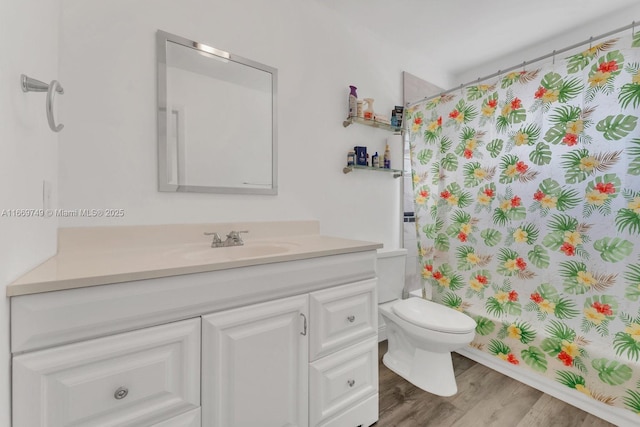 full bathroom featuring hardwood / wood-style floors, vanity, shower / tub combo, and toilet