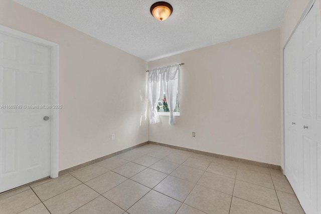 tiled spare room with a textured ceiling