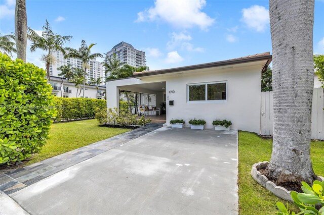 view of front of home with a front lawn and a carport