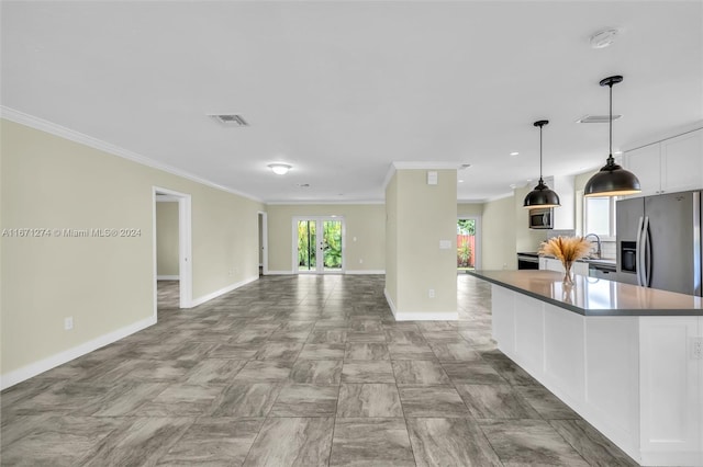 kitchen featuring appliances with stainless steel finishes, decorative light fixtures, crown molding, a center island, and white cabinets