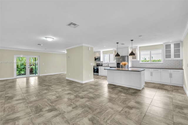 kitchen with stainless steel appliances, a wealth of natural light, white cabinetry, and backsplash