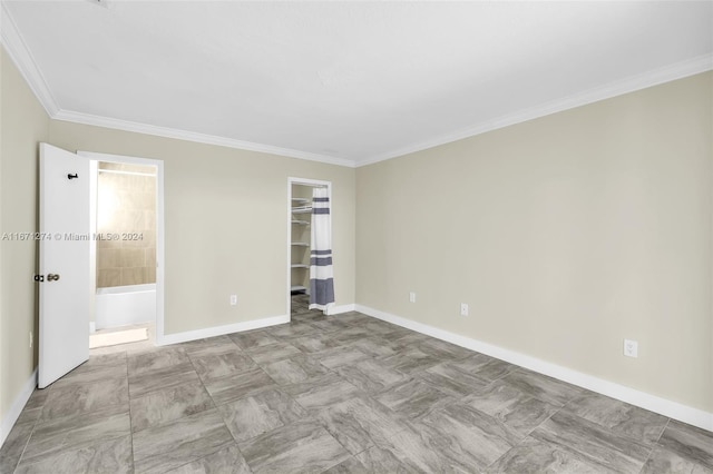 unfurnished bedroom with crown molding, a closet, and a spacious closet