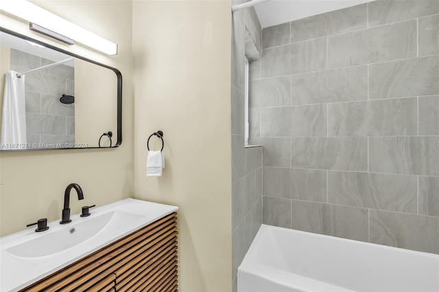 bathroom featuring vanity and tiled shower / bath