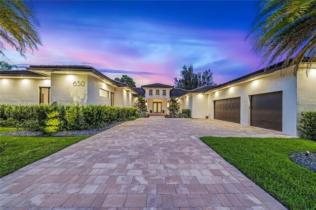 view of front of home with a garage and a lawn