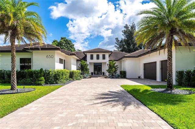 mediterranean / spanish home with a front yard and a garage