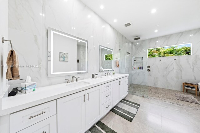 bathroom with vanity, a wealth of natural light, tile walls, and tiled shower