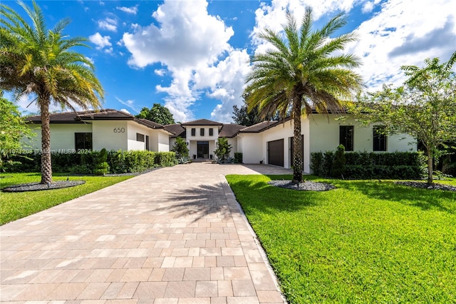 mediterranean / spanish-style house featuring a garage and a front lawn