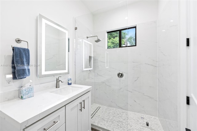 bathroom with vanity and a tile shower