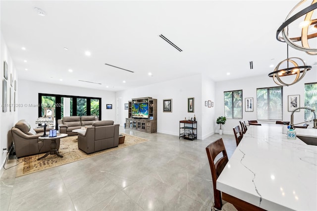 living room featuring a notable chandelier and sink