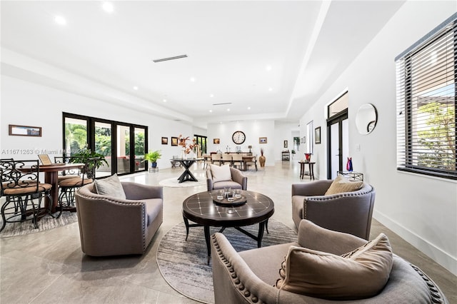 living room featuring french doors and a raised ceiling