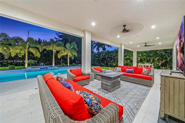 patio terrace at dusk featuring ceiling fan and an outdoor hangout area