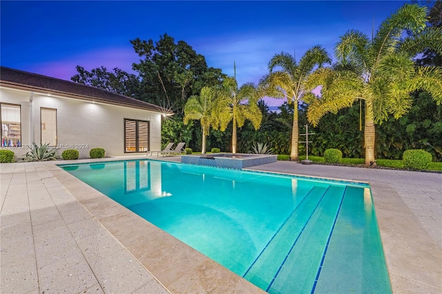 pool at dusk with a patio