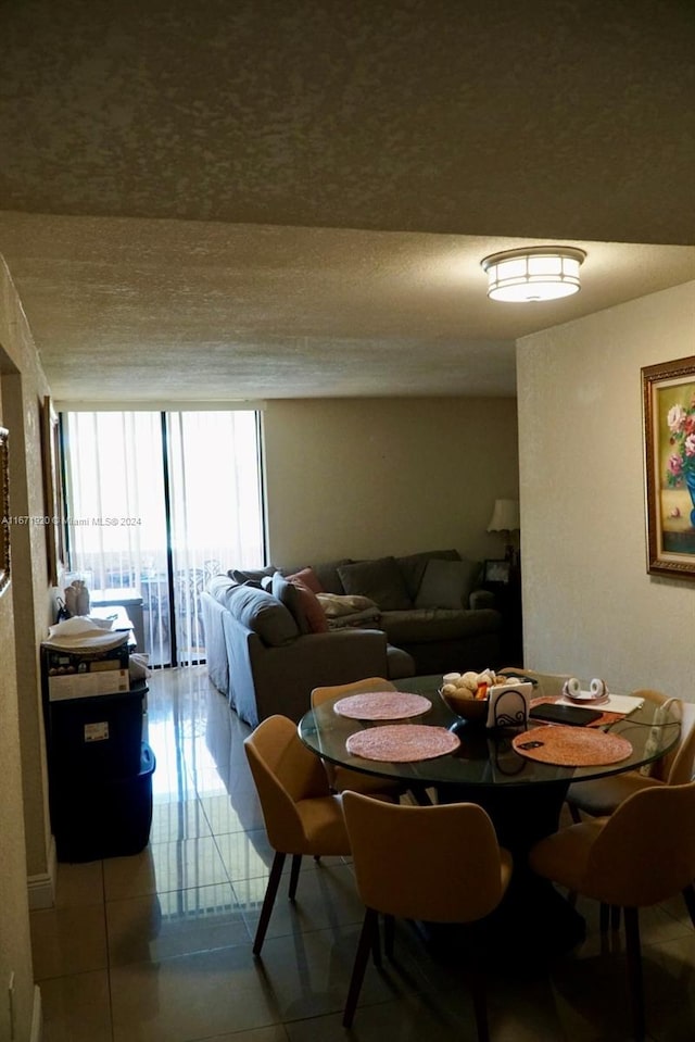 dining space featuring a textured ceiling and light tile patterned floors