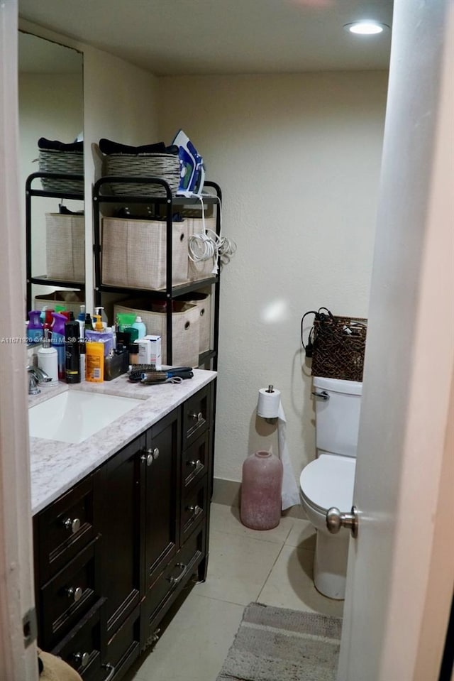 bathroom featuring tile patterned flooring, vanity, and toilet