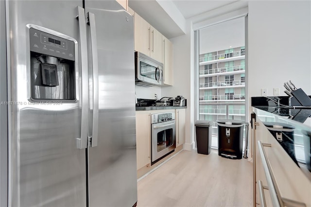 kitchen with appliances with stainless steel finishes and light hardwood / wood-style floors