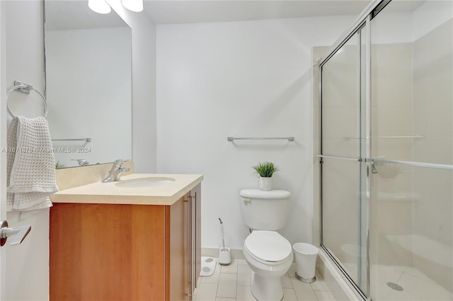 bathroom with vanity, tile patterned flooring, toilet, and an enclosed shower