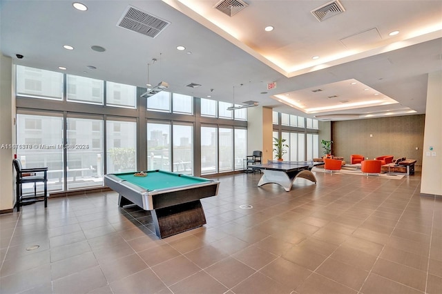 recreation room with billiards, a tray ceiling, and light tile patterned floors