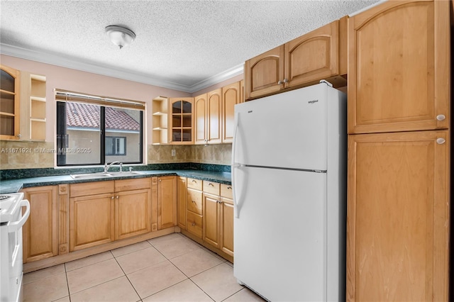 kitchen with sink, white refrigerator, stove, light tile patterned floors, and crown molding