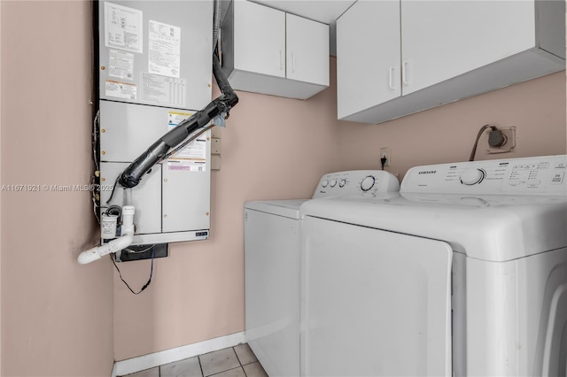 laundry area with cabinets, washing machine and dryer, heating unit, and light tile patterned floors