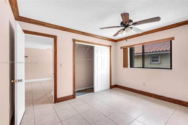 unfurnished bedroom featuring light tile patterned floors, ceiling fan, ornamental molding, a textured ceiling, and a closet