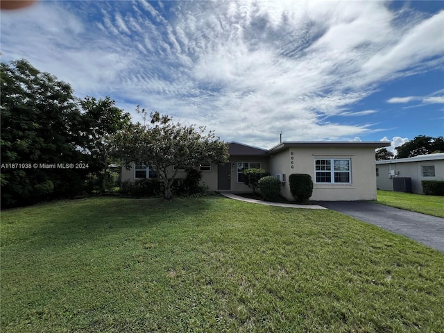 ranch-style house with cooling unit and a front lawn