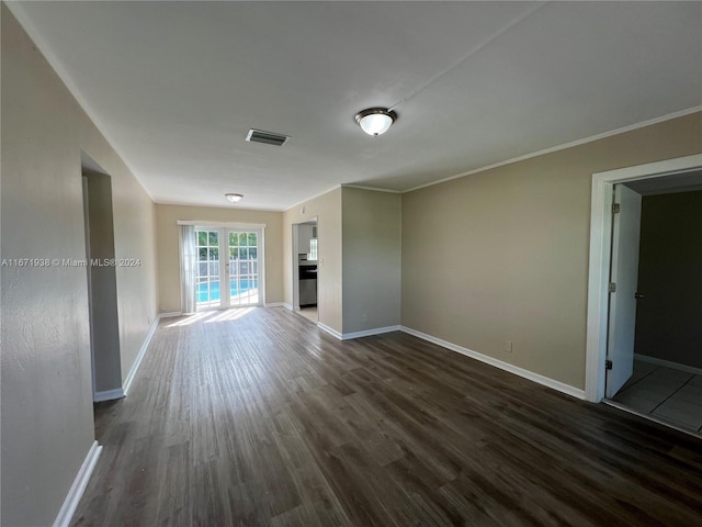 unfurnished living room featuring french doors, ornamental molding, and dark wood-type flooring