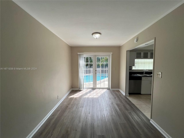 interior space with sink, light wood-type flooring, and ornamental molding