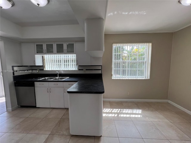 kitchen with light tile patterned flooring, stainless steel dishwasher, sink, and white cabinetry