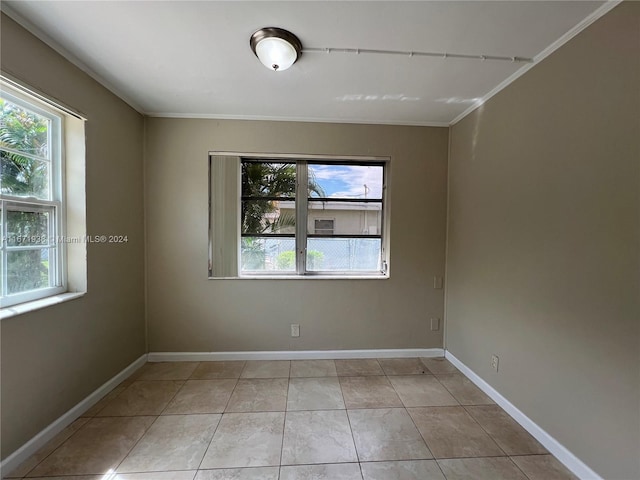 unfurnished room with crown molding, light tile patterned floors, and a wealth of natural light