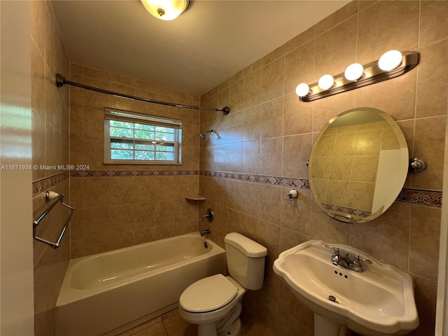 full bathroom with tiled shower / bath, sink, tile walls, and toilet