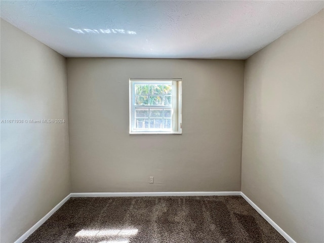 unfurnished room with a textured ceiling and carpet floors