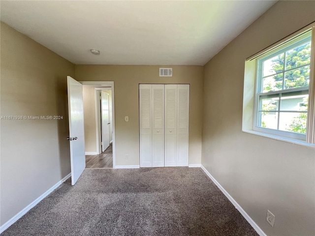 unfurnished bedroom with carpet flooring and a closet