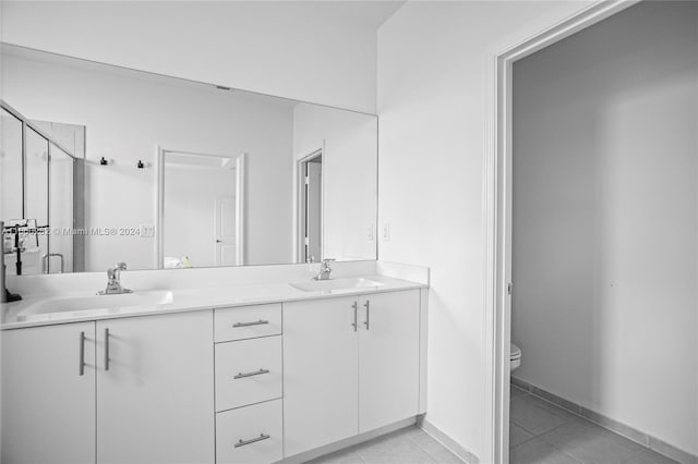 bathroom with vanity, toilet, an enclosed shower, and tile patterned floors