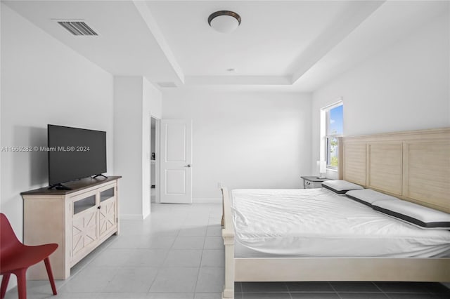 tiled bedroom with a tray ceiling