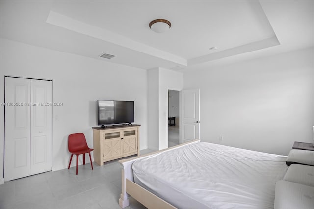 bedroom with a closet and a raised ceiling