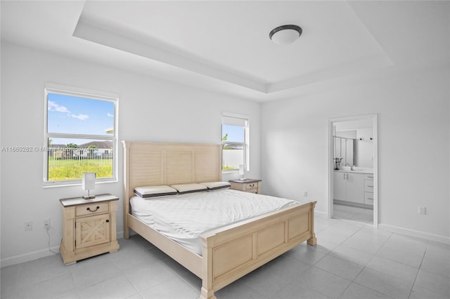 bedroom with a tray ceiling and ensuite bath