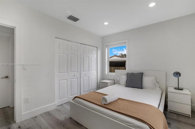 bedroom with light wood-type flooring and a closet